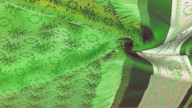 yeşil ipek kumaş. Pürüzsüz yeşil ipek ya da saten lüks kumaş dokusu soyut bir arkaplan olarak kullanılabilir. Lüks arka plan tasarımı. Doku, desen