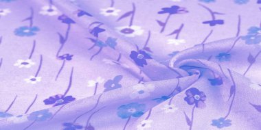 İpek kumaş, eflatun arkaplanda küçük çiçekler, ince bir desenli gök mavisi. Çiçek tasarımı. Arkaplan dokusu