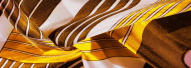 Doku, arkaplan, sarı çizgili ipek kumaş. Bu kumaşın tasarımı muhteşem bir yeleğin görünümünü temsil eden beyaz tavşan mozaiğine adanmıştır..