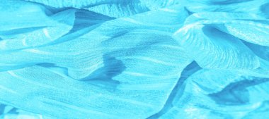 İpek kumaş. Mavi buruşuk kumaş dokusu. Mavi buruşuk, dalgalı yüzey dokusu. Yakın çekim, yumuşak odaklanma. arkaplan, kalıp