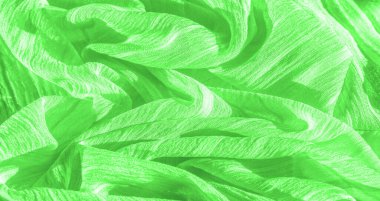 İpek kumaş. Yeşil kırışık kumaş dokusu. Yeşil buruşuk, dalgalı yüzey dokusu. Yakın çekim, yumuşak odaklanma. arkaplan, kalıp