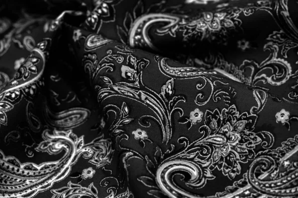 Paisley black-white pattern on a black background. decorated the bandanas of cowboys and bikers popularized by The Beatles, ushered in the era of hippies and became the emblem of rock and roll.