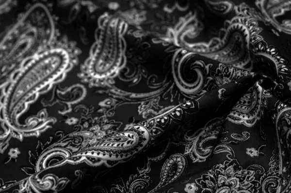 Paisley black-white pattern on a black background. decorated the bandanas of cowboys and bikers popularized by The Beatles, ushered in the era of hippies and became the emblem of rock and roll.