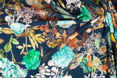 Örme kumaş. Çiçekler, meyveler ve kelebekler siyah bir arka plan. doku. Fotoğraf stüdyosu