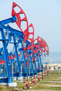Petrol ve gaz endüstrisi. yağ pompası jack petrol sahası üzerinde çalışır. beyaz bulutlar ve mavi gökyüzü. Petrol pompası. Petrol ve gaz endüstrisi. yağ pompası jack petrol sahasındaki çalışmaları.