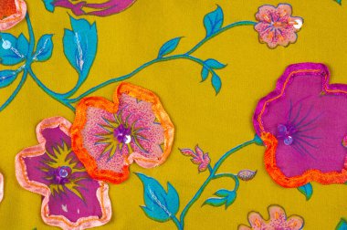 exture ipek kumaştan. Çiçek işlemeli yeşil arka plan üzerinde