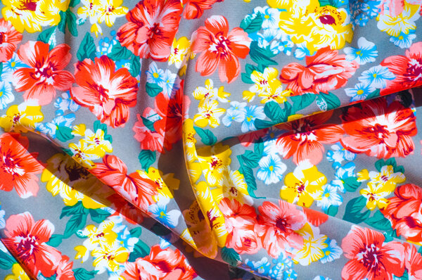 текстура шелковая ткань. Желто-красные цветы, нарисованные на ткани
