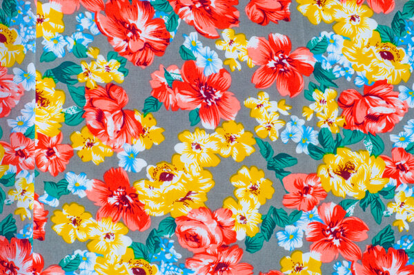 текстура шелковая ткань. Желто-красные цветы, нарисованные на ткани
