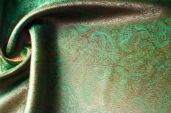 The texture of the silk fabric, painted with a brown green pattern.  macro texture of brown striped fabric studio. Artistic fabric texture, folded, wavy.
