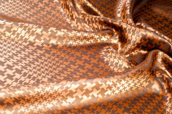 The texture of the silk fabric, painted with a brown pattern.  macro texture of brown striped fabric studio. Artistic fabric texture, folded, wavy.