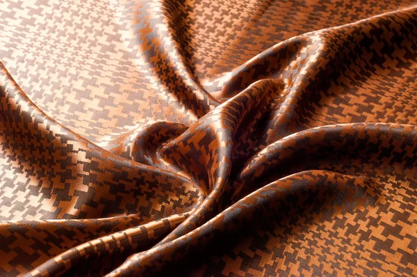 The texture of the silk fabric, painted with a brown pattern.  macro texture of brown striped fabric studio. Artistic fabric texture, folded, wavy.