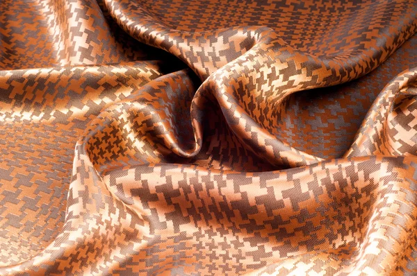 The texture of the silk fabric, painted with a brown pattern.  macro texture of brown striped fabric studio. Artistic fabric texture, folded, wavy.