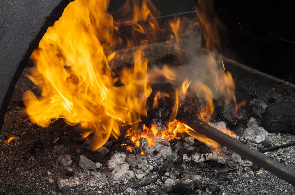 Stock image Old-fashioned blacksmith furnace with burning coals. Embers and Flame of a smith's forge. Heated bugle with red coals. 