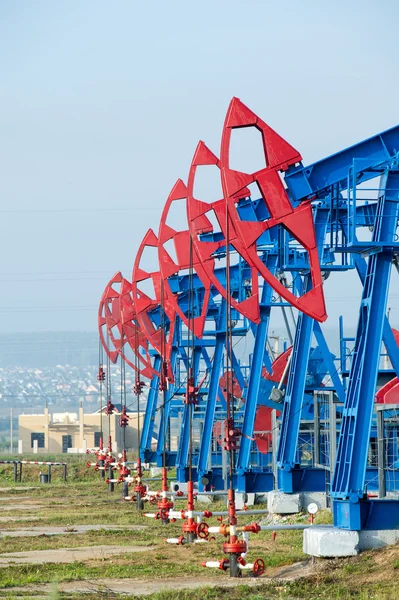 石油およびガス産業 油ポンプ ジャック オイル フィールドでの作業 白い雲と青い空 油井ポンプです 石油およびガス産業 油ポンプ ジャック — ストック写真