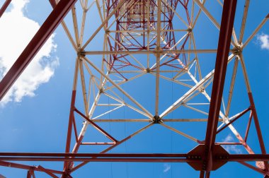 Doku enerji ayağı. Elektrik pilon mavi gökyüzü karşı detay: yüksek gerilim elektrik direği aşağıdan
