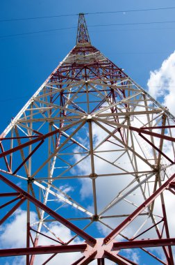 Doku enerji ayağı. Elektrik pilon mavi gökyüzü karşı detay: yüksek gerilim elektrik direği aşağıdan