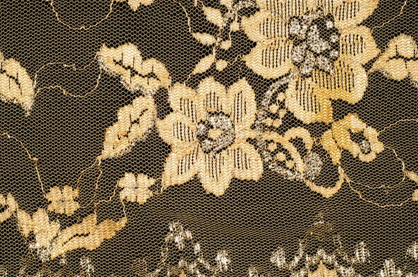 Tekstura. Koronki tkaniny złoty żółty kolor Zdjęcia wykonane w sworzniu — Zdjęcie stockowe