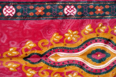 Doku kırmızı desenli ipek kumaştan. Kırmızı kumaş Galli armut ile fotoğraflandı yakın çekim var. Hint çiçek desenli doğal ipek kumaş üzerine salatalık ile.