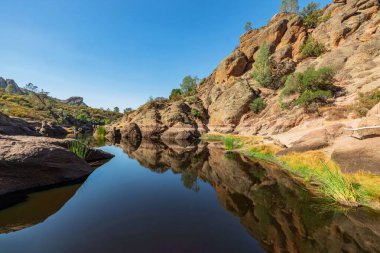 Kaliforniya Pinnacles Ulusal Parkı 'ndaki Bear Gulch Gölü ve kaya oluşumları, San Andreas Fayı' ndaki sönmüş bir volkanın kalıntıları. Güzel manzaralar, turistler için rahat yürüyüş yolları.