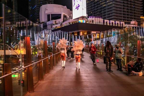 LAS VEGAS - 11 de noviembre de 2020, una pluma de niña se para en una calle nocturna iluminada por luces multicolores, Las Vegas es la capital mundial del negocio de los juegos de azar. — Foto de Stock