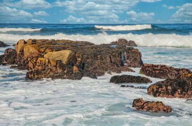 Kaliforniya 'nın Pasifik kıyılarının güzel deniz manzarası, dalgalar, kayalar, gökyüzü, güneş. Konsept, mükemmel kartpostal ve rehber.