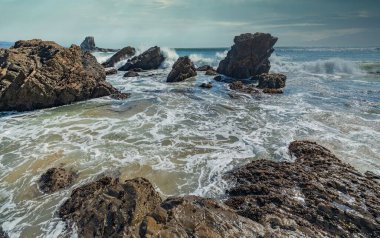 Kaliforniya 'nın Pasifik kıyılarının güzel deniz manzarası, dalgalar, kayalar, gökyüzü, güneş. Konsept, mükemmel kartpostal ve rehber.