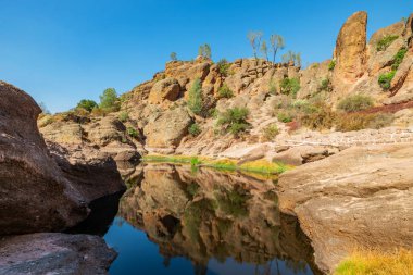 Kaliforniya Pinnacles Ulusal Parkı 'ndaki Bear Gulch Gölü ve kaya oluşumları, San Andreas Fayı' nda sönmüş bir volkanın kalıntıları. Güzel manzaralar, turistler ve gezginler için rahat yürüyüş yolları..