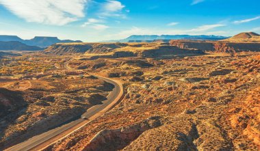 İnsansız hava aracından gelen hava manzarası, ABD 'nin Utah kentindeki yol boyunca kırmızı ve turuncu kaya oluşumlarının güzel manzarası.