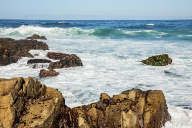 Pasifik sahilinin güzel deniz manzarası, California, dalgalar, kayalar, gökyüzü, güneş. Konsept, mükemmel kartpostal ve rehber.