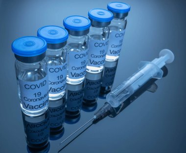 Koronavirüs enfeksiyonuna karşı enjeksiyon için COVID-19 aşısı ve iğneli bir şırınga. Yakın plan. Coronavirus kavramına karşı savaş