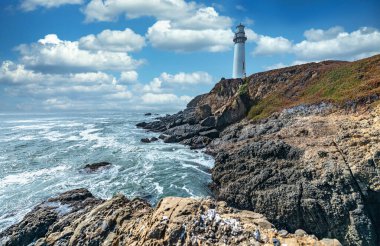 Pigeon Point deniz feneri, güzel bir gökyüzünün arkaplanına karşı, ve dalgalı okyanus, California 'daki Pasifik kıyılarının muhteşem manzarası.