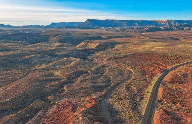 İnsansız hava aracından gelen hava manzarası, ABD 'nin Utah kentindeki yol boyunca kırmızı ve turuncu kaya oluşumlarının güzel manzarası.