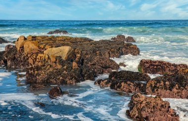 Pasifik sahilinin güzel deniz manzarası, California, dalgalar, kayalar, gökyüzü, güneş. Konsept, mükemmel kartpostal ve rehber.
