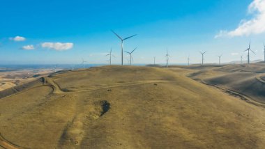 Kaliforniya 'da, tepelerde, yaz mevsiminde, bulutlu açık güneşli bir havada rüzgar çiftliği. Kavram, saf enerji, doğanın.