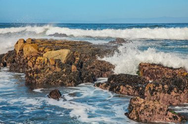 Pasifik sahilinin güzel deniz manzarası, California, dalgalar, kayalar, gökyüzü, güneş. Konsept, mükemmel kartpostal ve rehber.
