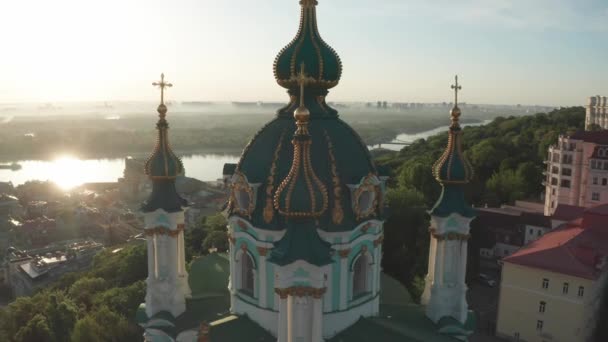 Letecký pohled na kostel sv. Andrewse při východu slunce, historické centrum, Podolská čtvrť, Kyjev, Ukrajina. Dron s kamerou letí z kostela svatého Ondřeje. Létat kolem kostela St. Andrews v Kyjevě. — Stock video