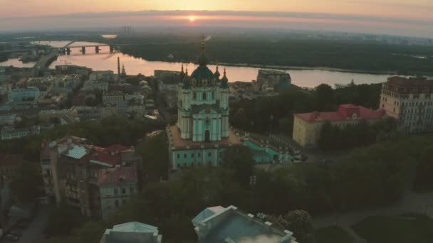 Vue aérienne de l'église St. Andrews au lever du soleil, centre historique, district de Podolsk, Kiev, Ukraine. Un drone avec une caméra vole de l'église Saint-André. Volez autour de l'église St. Andrews à Kiev. — Video