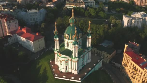 Letecký pohled na kostel sv. Andrewse při východu slunce, historické centrum, Podolská čtvrť, Kyjev, Ukrajina. Dron s kamerou letí z kostela svatého Ondřeje. Létat kolem kostela St. Andrews v Kyjevě. — Stock video