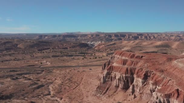 Vista aérea. Vuela sobre las rocas rojas de un cañón en el seco y soleado desierto de Utah en el oeste de Estados Unidos. — Vídeo de stock