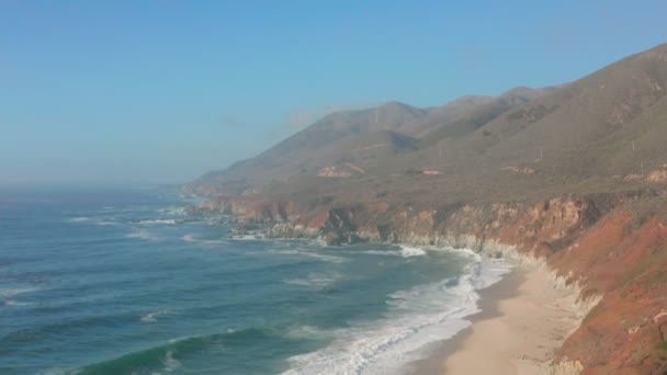 大気圏の眺め、太平洋の波は、北カリフォルニアの頑丈な海岸を洗い流します。太平洋岸景観道路はカリフォルニア州の大半を通っている。. — ストック動画