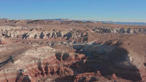 Vista aérea. Vuela sobre las rocas rojas de un cañón en el seco y soleado desierto de Utah en el oeste de Estados Unidos. — Vídeo de stock