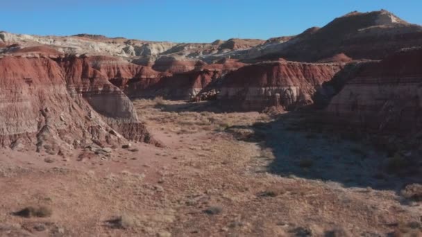 Vista aérea. Vuela sobre las rocas rojas de un cañón en el seco y soleado desierto de Utah en el oeste de Estados Unidos. — Vídeo de stock
