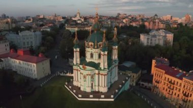 Gündoğumunda St. Andrews Kilisesi 'nin havadan görünüşü, tarihi merkez, Podolsk bölgesi, Kiev, Ukrayna. Kameralı bir dron St. Andrew Kilisesi 'nden uçuyor. Kiev 'deki St. Andrews Kilisesi' nde dolaş..