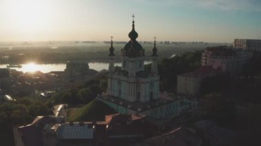 Gündoğumunda St. Andrews Kilisesi 'nin havadan görünüşü, tarihi merkez, Podolsk bölgesi, Kiev, Ukrayna. Kameralı bir dron St. Andrew Kilisesi 'nden uçuyor. Kiev 'deki St. Andrews Kilisesi' nde dolaş..