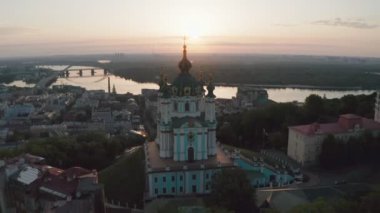 Gündoğumunda St. Andrews Kilisesi 'nin havadan görünüşü, tarihi merkez, Podolsk bölgesi, Kiev, Ukrayna. Kameralı bir dron St. Andrew Kilisesi 'nden uçuyor. Kiev 'deki St. Andrews Kilisesi' nde dolaş..