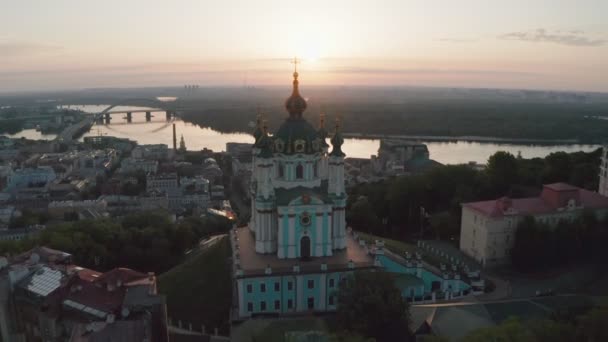 Luchtfoto van St. Andrews kerk bij zonsopgang, historisch centrum, Podolsk district, Kiev, Oekraïne. Een drone met een camera vliegt vanuit de kerk van St. Andrew. Vlieg rond St. Andrews kerk in Kiev. — Stockvideo