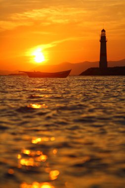 Gün batımında deniz manzarası. Sahildeki deniz feneri. Deniz kenti Turgutreis ve muhteşem gün batımları