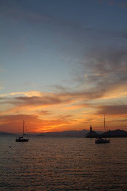 Gün batımında deniz manzarası. Sahildeki deniz feneri. Deniz kenti Turgutreis ve muhteşem gün batımları