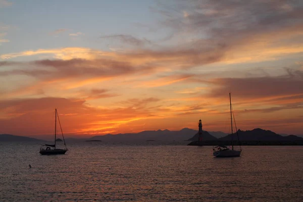 Gün batımında deniz manzarası. Sahildeki deniz feneri. Deniz kenti Turgutreis ve muhteşem gün batımları