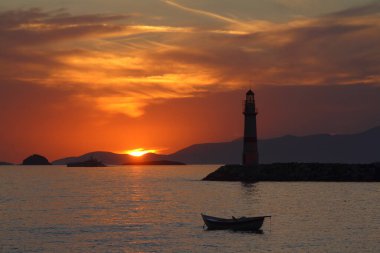 Gün batımında deniz manzarası. Sahildeki deniz feneri. Deniz kenti Turgutreis ve muhteşem gün batımları